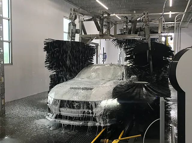 A car covered in foam going through the Premier Car Wash tunnel